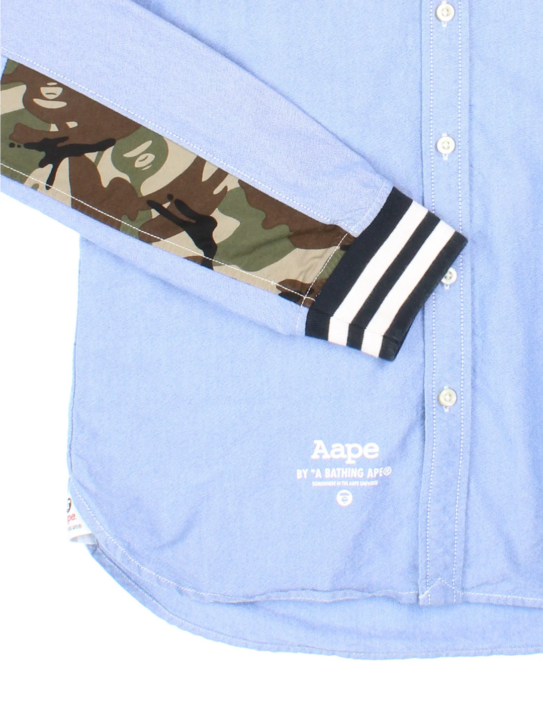 A Bathing Ape By Bape Oxford Shirt in a blue colourway and has camo panelling by on the sleeves, button up with the logo embroidered on the front.