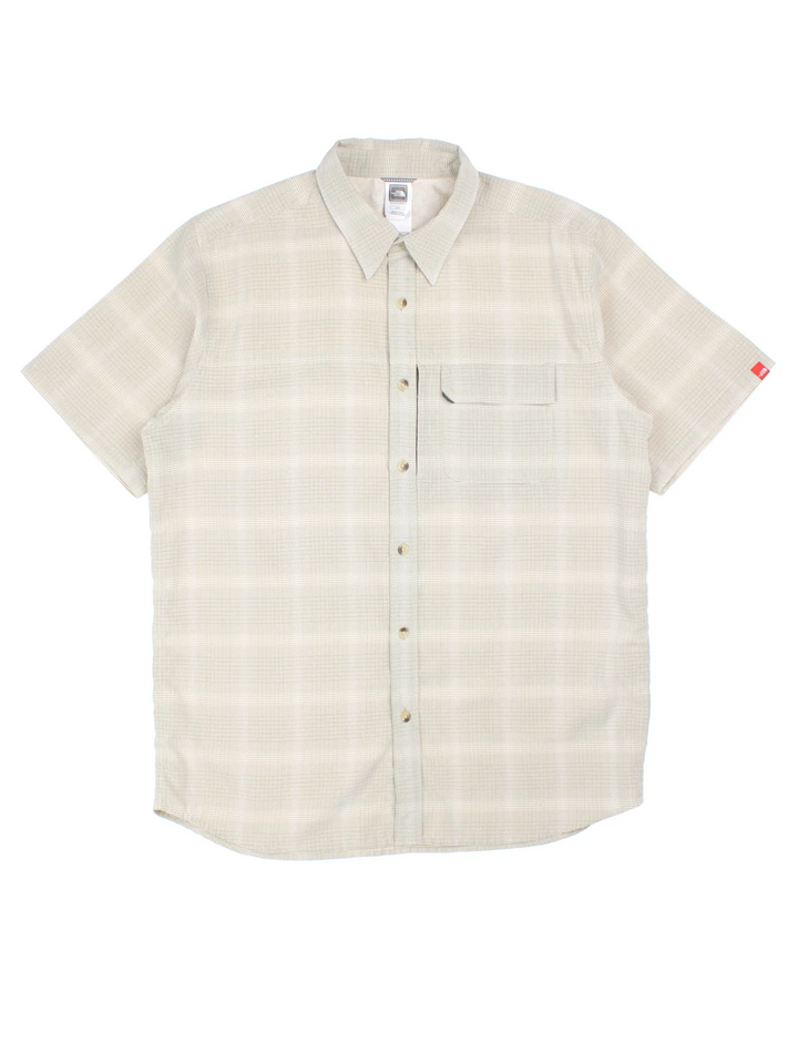 The North Face Shirt in a tan colourway and plaid pattern all over, button up and has a chest pocket with the logo embroidered on the front.