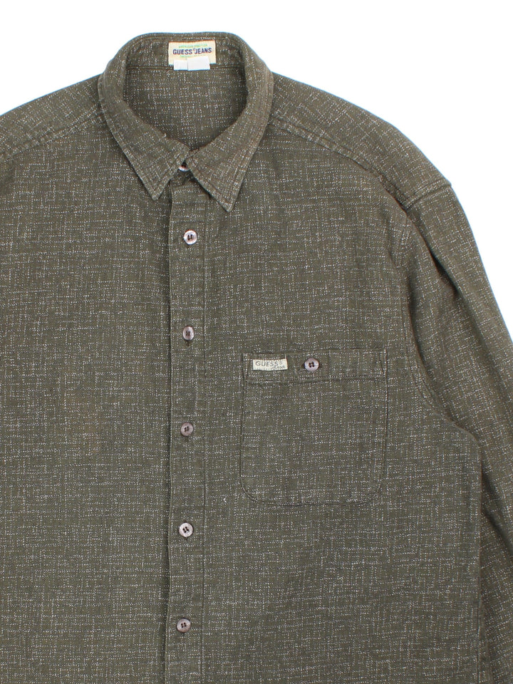 Guess Flannel Shirt in a green colourway with light fleck pattern. Classic button up with front pocket.