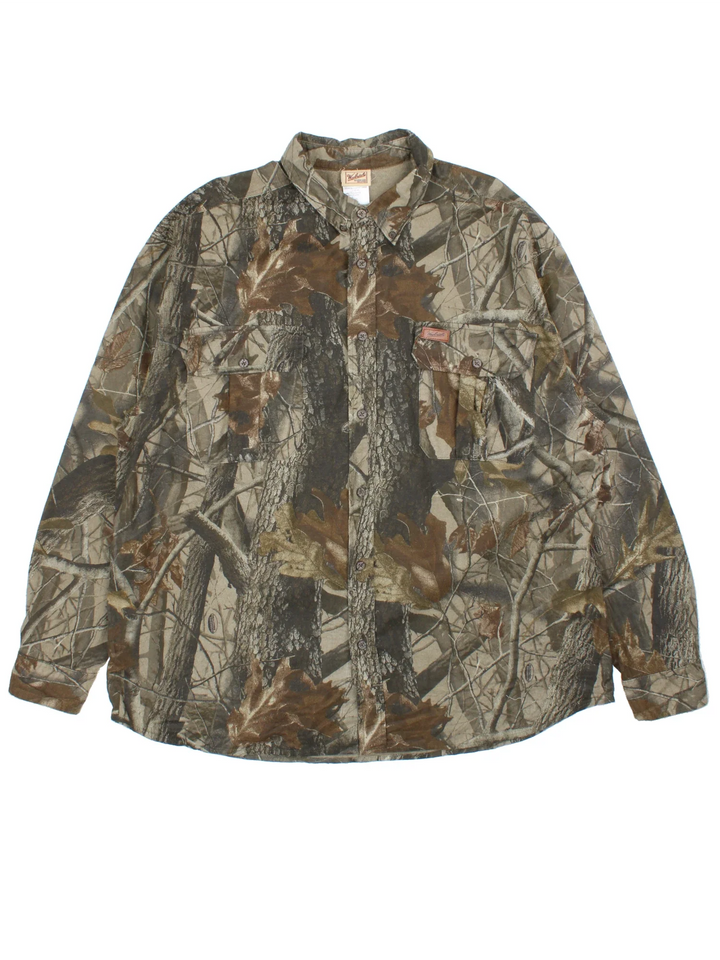 Woolrich Real Tree Camo Shirt in a green and brown colourway, button up and has double chest pockets with the logo embroidered on the front.