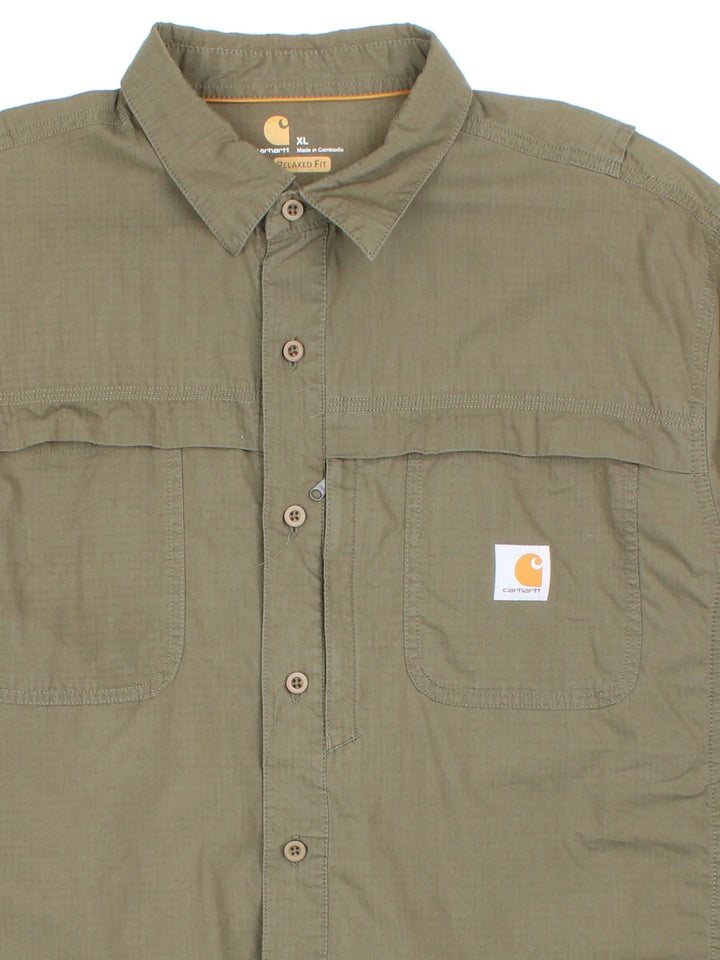 Carhartt Shirt in a green colourway, button up and has multiple tech style pockets with the logo embroidered on the front.