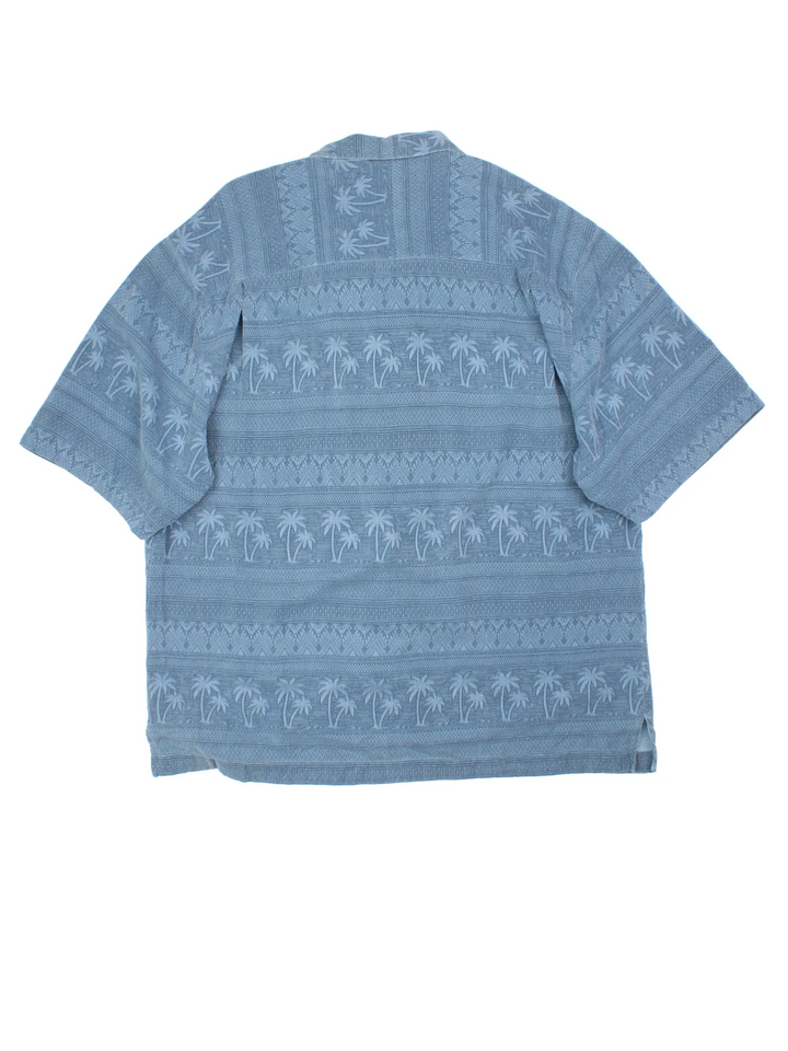 Vintage Hawaiian Shirt in a blue colourway with palm tree pattern all over, button up and has a chest pocket.