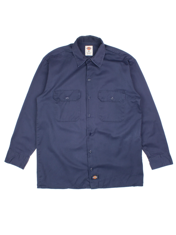 Dickies Work Shirt in a blue colourway, button up and has double chest pockets and the logo embroidered on the front by the hem.