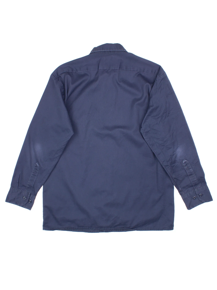 Dickies Work Shirt in a blue colourway, button up and has double chest pockets and the logo embroidered on the front by the hem.