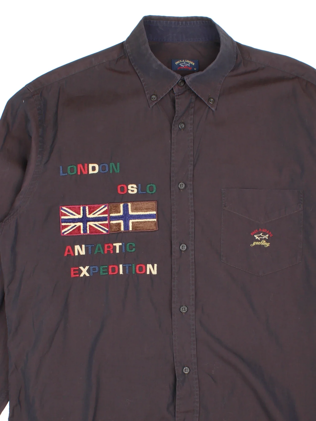 Paul & Shark Yatch Sailing Shirt in a black colourway, button up and has a chest pocket with the logo embroidered on the front alongside text and flags on the front, back and sleeves.