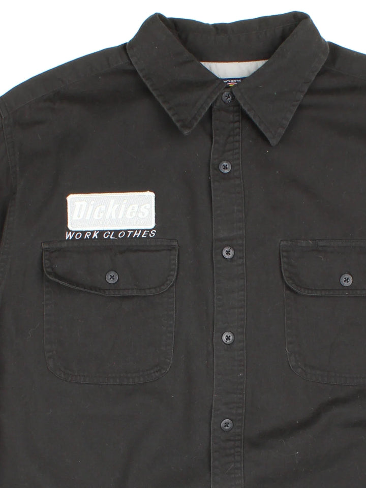 Dickies Work Shirt in a black colourway, button up and has double chest pockets with the logo embroidered on the front and left sleeve.