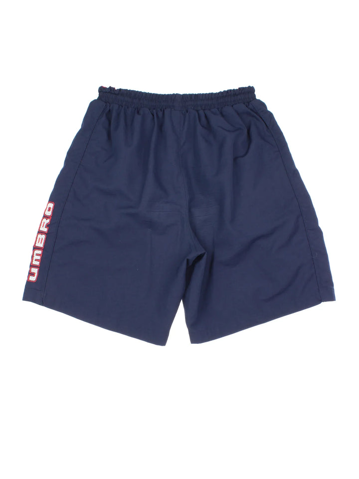 Vintage Umbro Swim Shorts in blue colourway with drawstring waist, contrast side branding and logo embroidered on front.