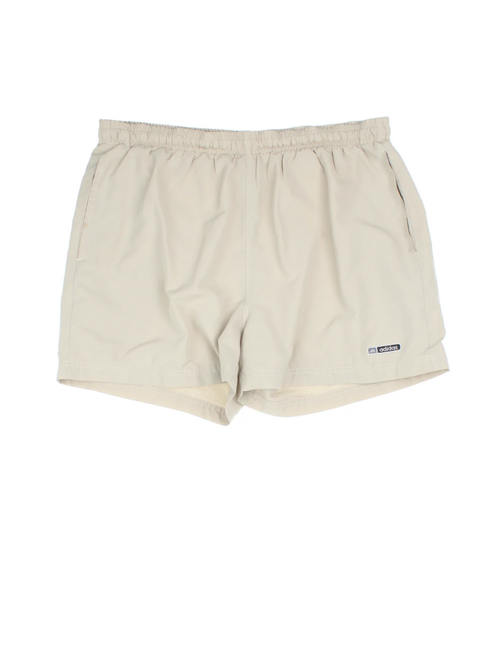 Adidas Shorts in tan colourway with pockets, elasticated waist with drawstring and the logo embroidered on the front.