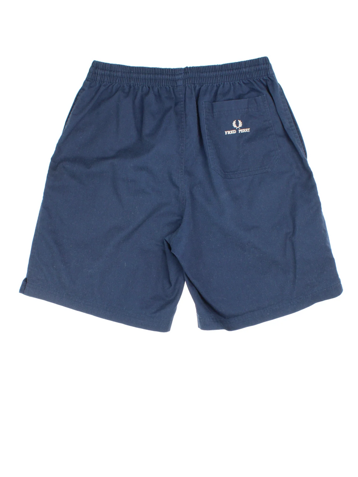 Vintage Fred Perry Shorts in blue colourway with elasticated waist, multiple pockets and the logo embroidered on the front/back.