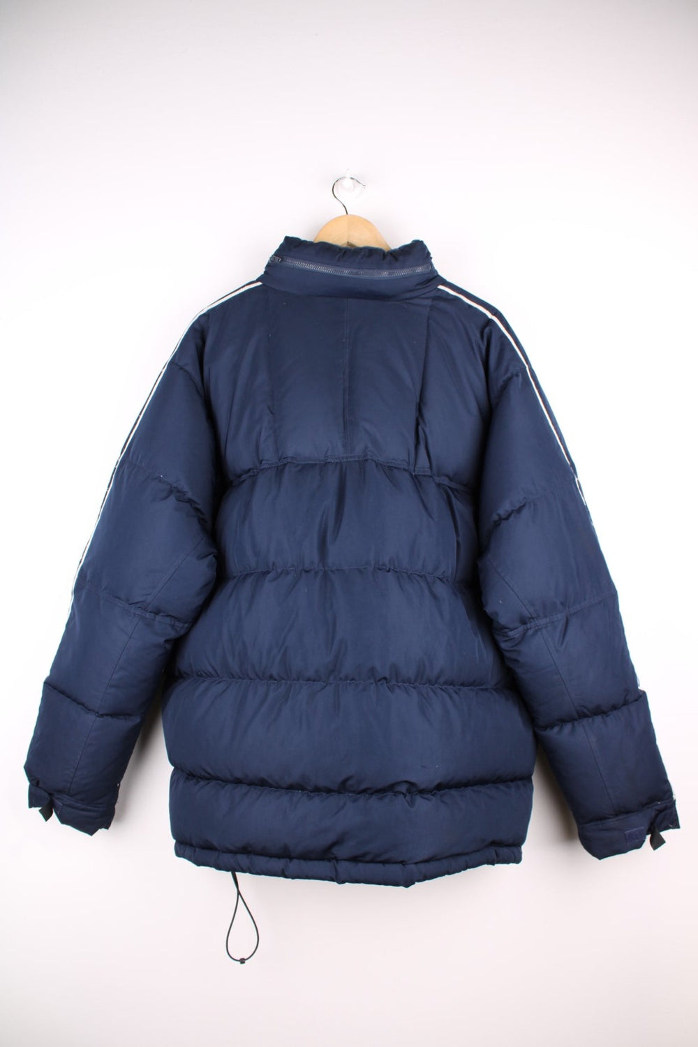 Vintage Nike Y2K era Puffer Coat in a navy blue colourway. The coat is filled with duck feather, has two zip pockets on the front panels and a zip away hood. There is also a small Nike logo stitched on the front. 