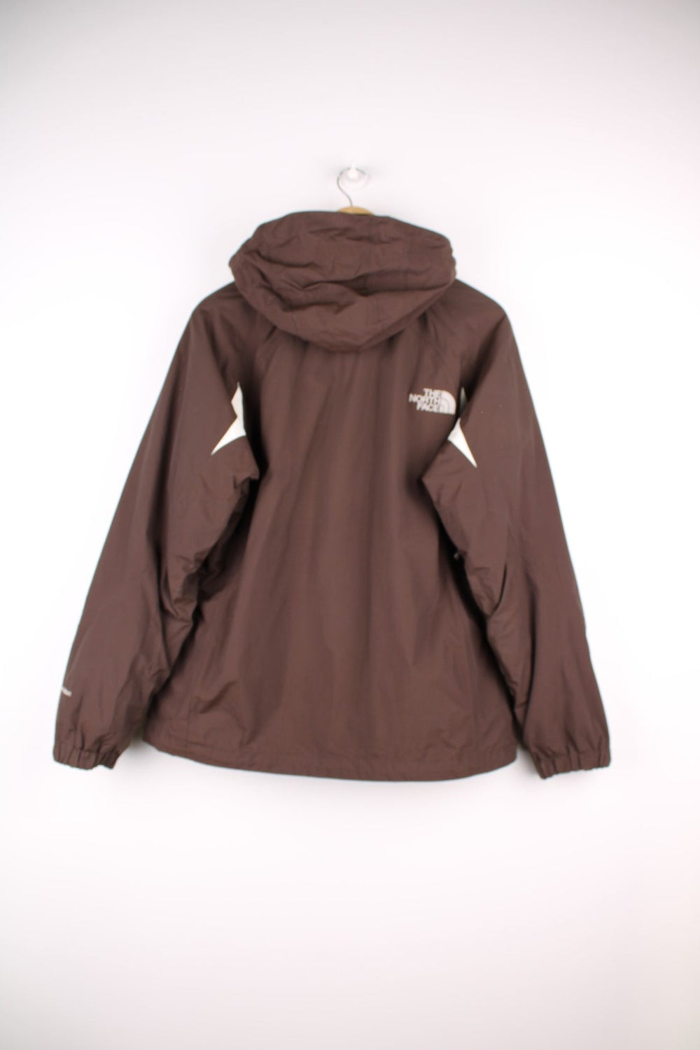The North Face Waterproof coat in brown. The jacket has a removable fleece lining, multiple pockets, and a removable hood.