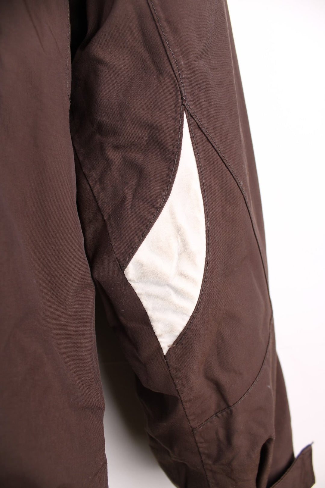 The North Face Waterproof coat in brown. The jacket has a removable fleece lining, multiple pockets, and a removable hood.