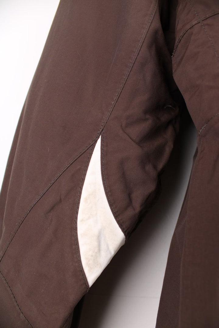 The North Face Waterproof coat in brown. The jacket has a removable fleece lining, multiple pockets, and a removable hood.