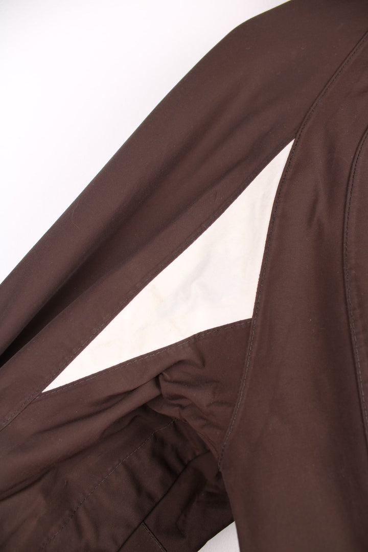 The North Face Waterproof coat in brown. The jacket has a removable fleece lining, multiple pockets, and a removable hood.