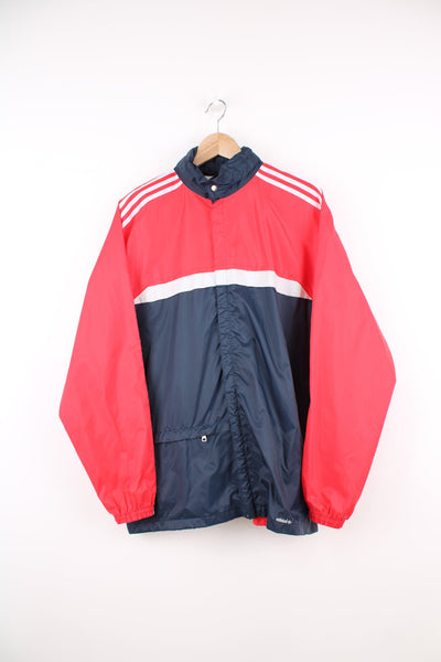 Vintage 80s Adidas lightweight windbreaker jacket. Features pack away hood, embroidered logo and signature three stripes on each sleeve. 