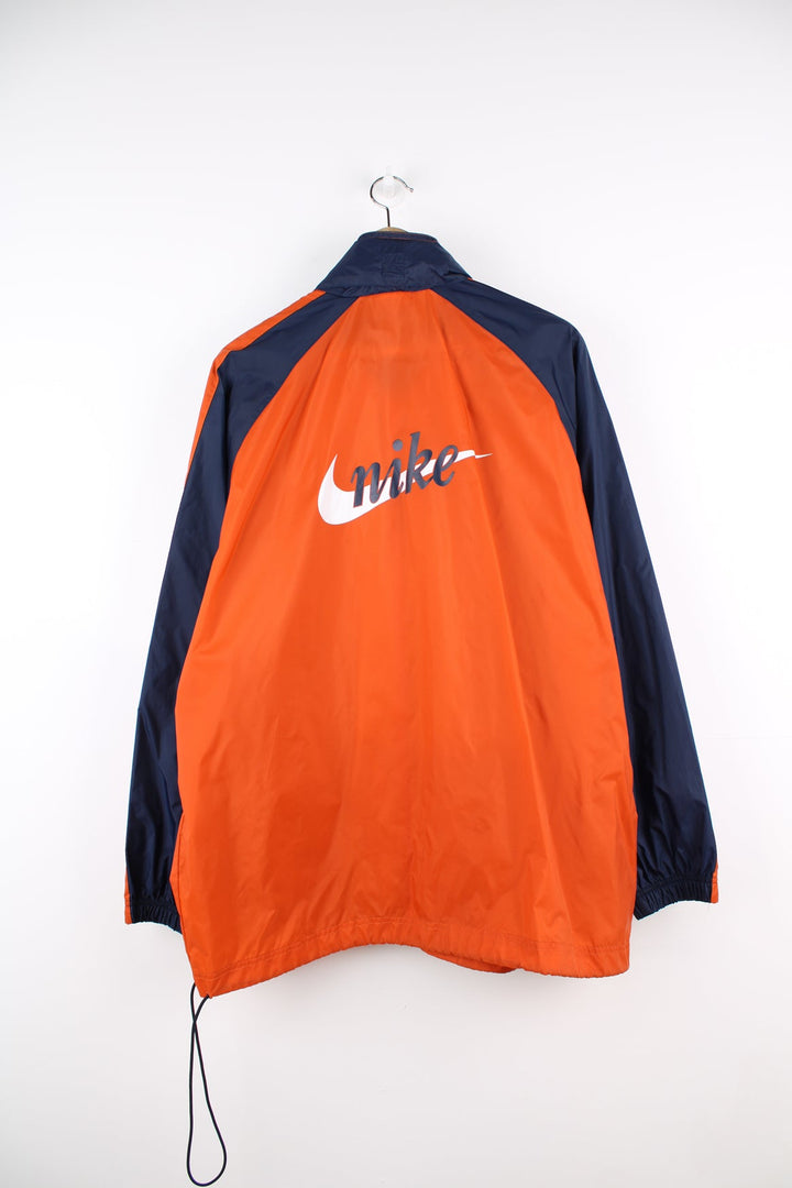 Vintage Nike lightweight windbreaker jacket in orange, blue and white. Features embroidered logo on the chest, printed logo on the back and a pack away hood.