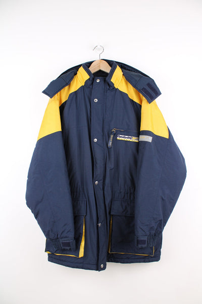 Vintage Reebok Athletic Dept blue and yellow coat. Features removable hood and embroidered logo.