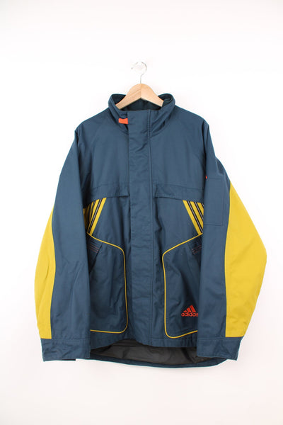 Vintage Adidas coat in blue and yellow. Features embroidered logo.