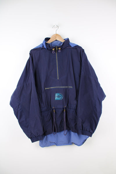Vintage 90s blue pullover tracksuit jacket with quarter zip. Features puff print logo, packaway hood and pouch pocket.