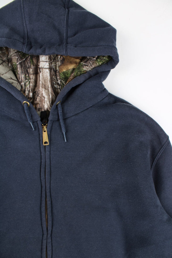 Carhartt Hoodie in a blue colourway with camo print lining. Large pocket and small classic logo on the front. 