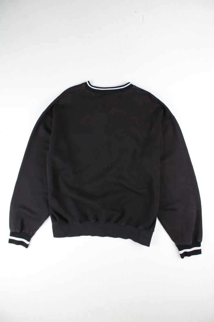 Vintage Reebok Drill Training Top in a black colourway with stripe detailing around the neck and cuffs. Small vintage logo on the chest.
