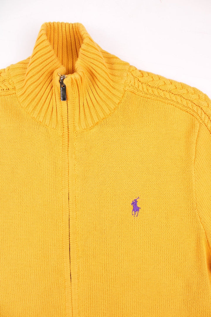 Ralph Lauren Sport zip cardigan in a mustard yellow colourway with the Ralph Lauren logo embroidered on the front chest panel. The knit has a cable knit pattern down the sleeves, ands two front pockets.
