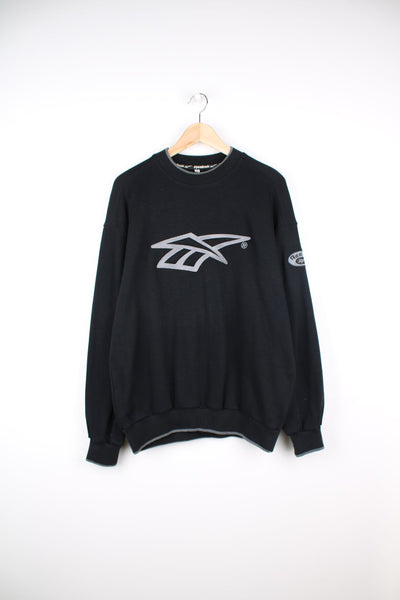 Black Reebok sweatshirt with grey embroidered logo on the chest and badge on the sleeve.