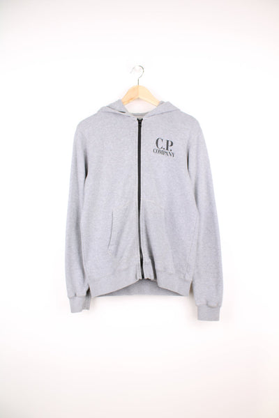 CP Company grey zip through hoodie with goggles and printed logo on the chest.