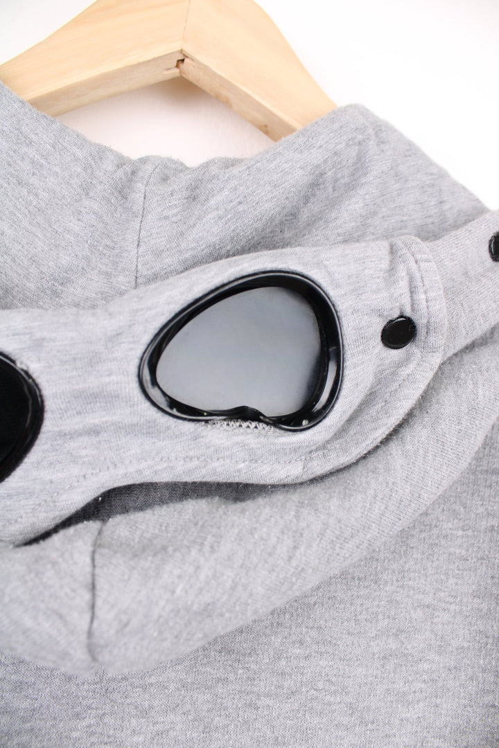 CP Company grey zip through hoodie with goggles and printed logo on the chest.