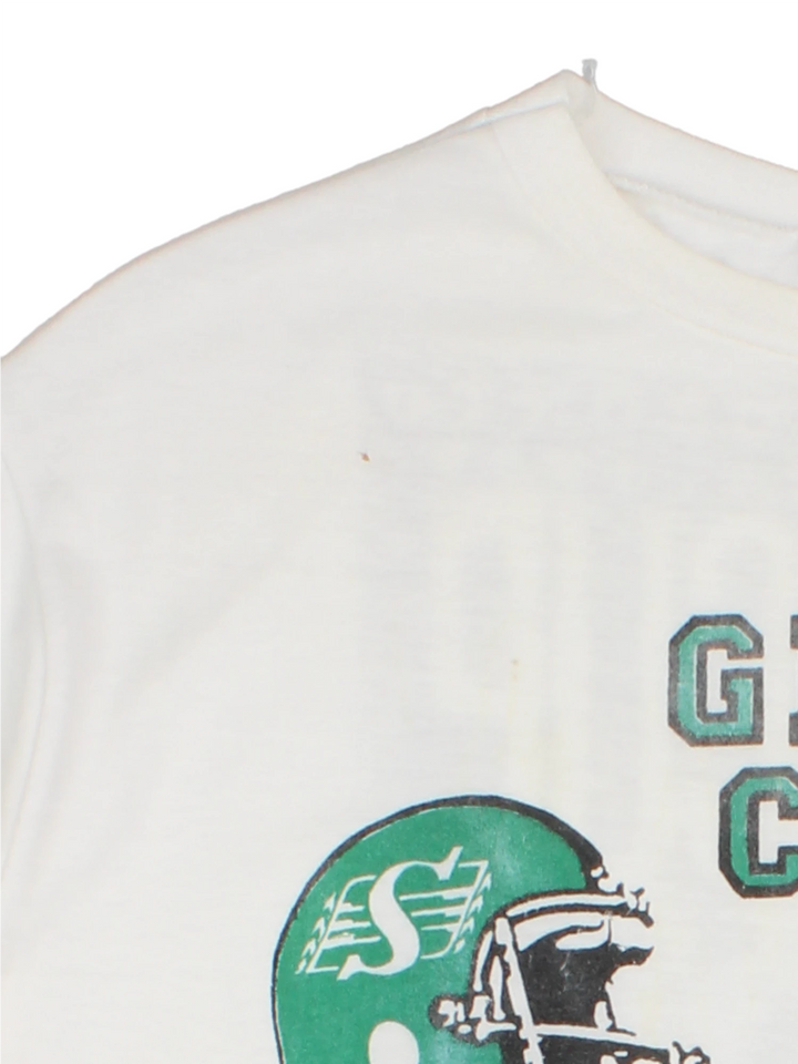 Vintage 1989 CFL Grey Cup Saskatchewan Roughriders vs Hamilton Tiger Cats tee in white with helmet face-off graphic on the front and photo of trophy on the back.