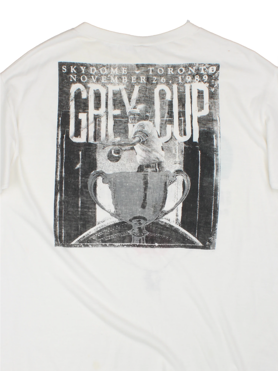 Vintage 1989 CFL Grey Cup Saskatchewan Roughriders vs Hamilton Tiger Cats tee in white with helmet face-off graphic on the front and photo of trophy on the back.