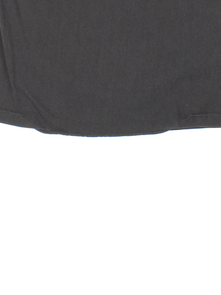 Vintage Stussy International Tribe T-Shirt in a black colourway with neon graphic and logo on the front.