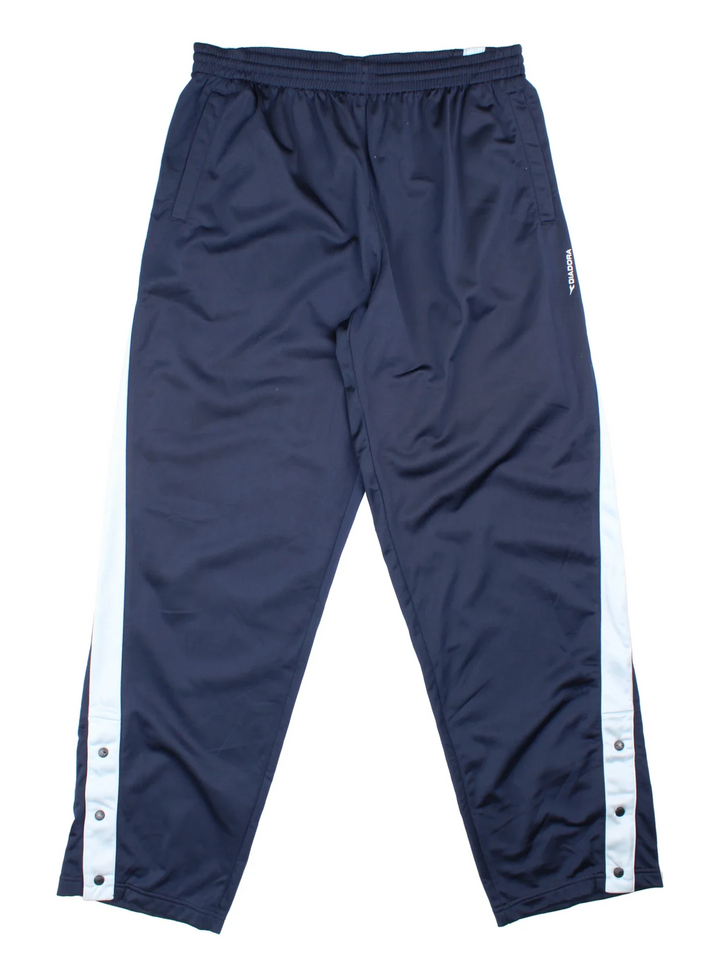 90's Diadora Tracksuit Bottoms in blue colourway. Side pockets, contrast piping and the logo embroidered on the front/back.
