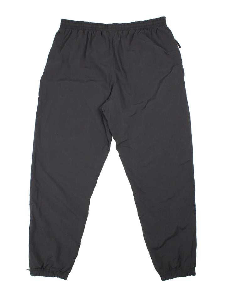 90's Nike Tracksuit Bottoms in black colourway. Side pockets, elasticated waist and the logo embroidered on the front.