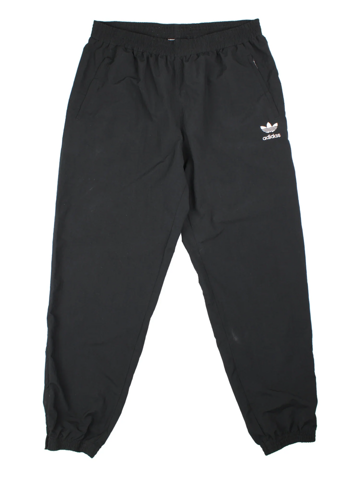 90's Adidas Tracksuit Bottoms in black colourway. Side pockets, elasticated waist and the logo embroidered on the front.