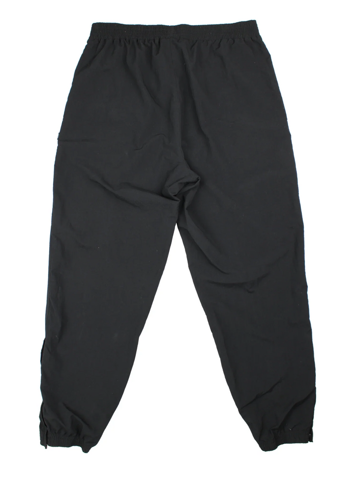 90's Adidas Tracksuit Bottoms in black colourway. Side pockets, elasticated waist and the logo embroidered on the front.