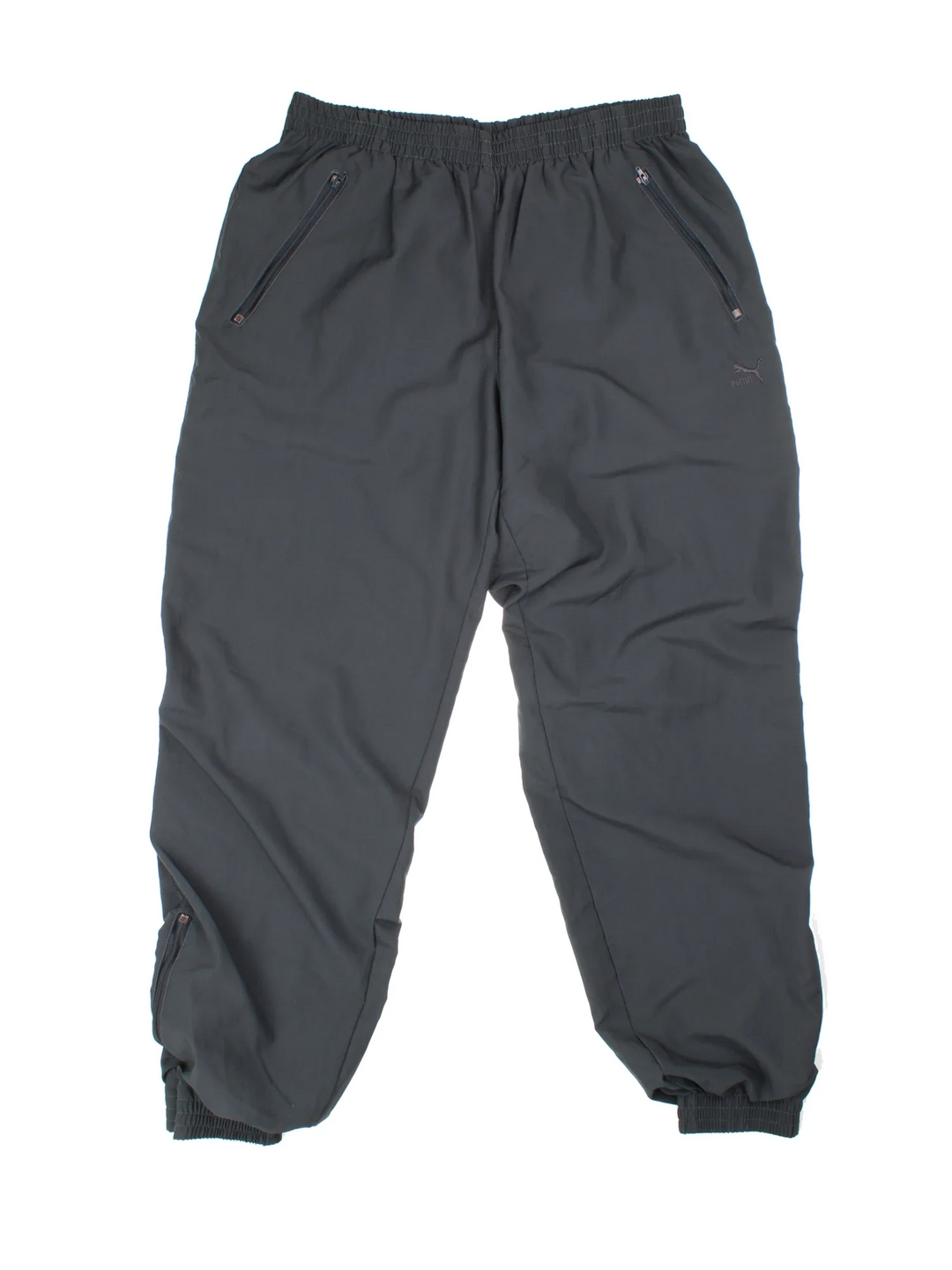 90's Puma Tracksuit Bottoms in black colourway with cuffed hem. Zipper ankle leg, side zip pockets and the logo embroidered on the front.