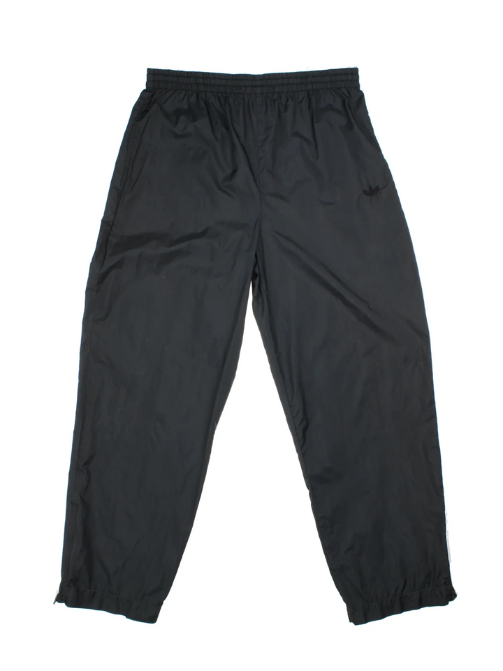 Vintage Adidas Tracksuit Shell Pants in a black colourway with pockets, adjustabe elasticated waist with drawstring and has the logo embroidered on the front.
