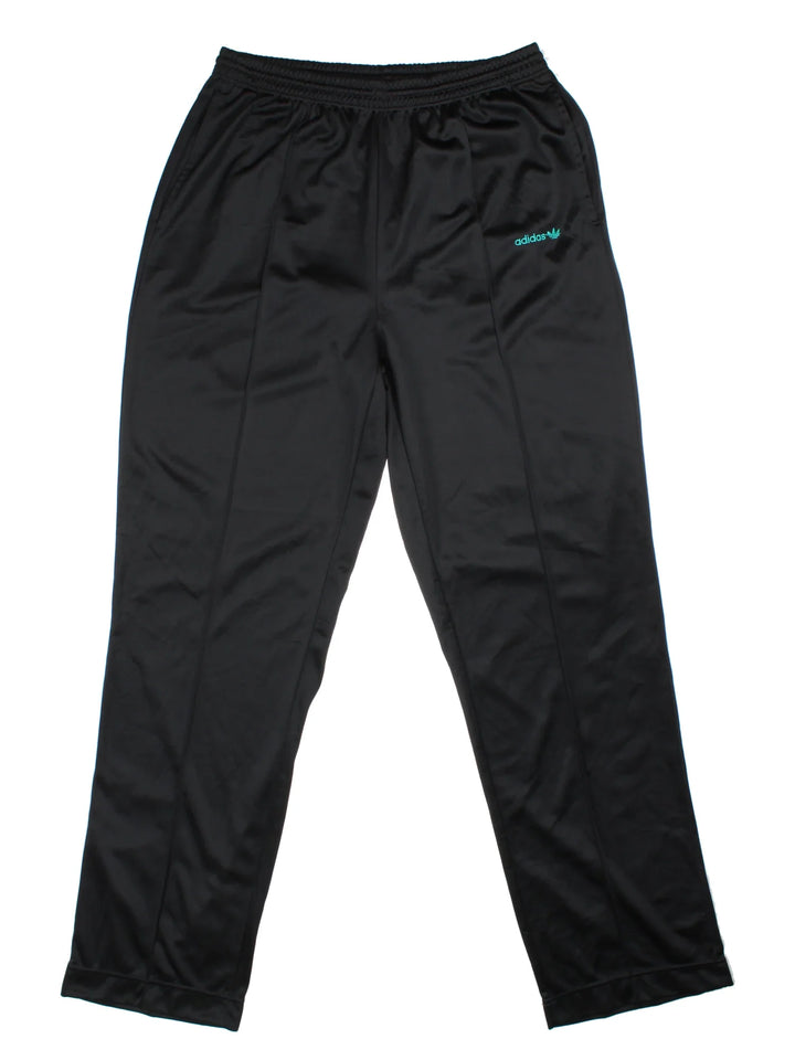Vintage Adidas Pleated Tracksuit Bottoms in a black colourway, has pockets, elasticated waist with drawstring, and the logo embroidered on the front.