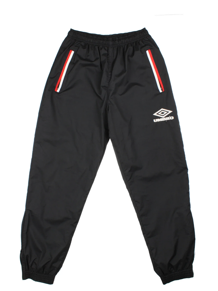 Umbro Tracksuit Bottoms in a black colourway with zip up side pockets, mesh lining, elasticated waist with drawstring, and the logo embroidered on the front.