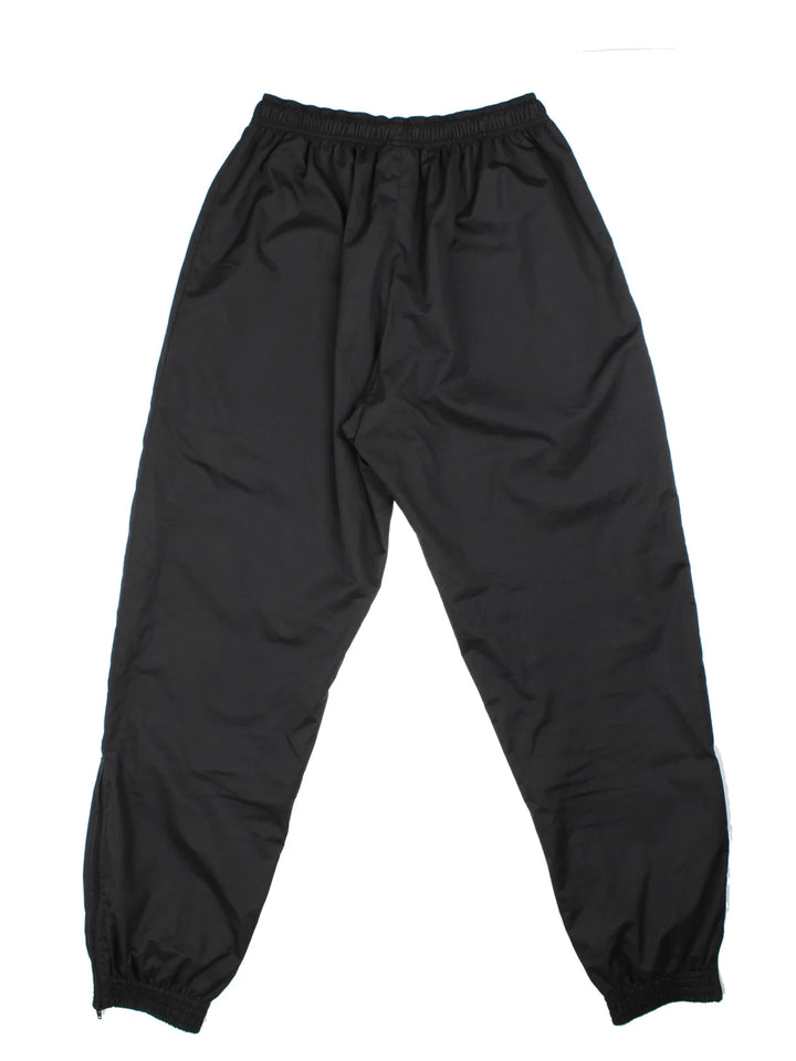 Umbro Tracksuit Bottoms in a black colourway with zip up side pockets, mesh lining, elasticated waist with drawstring, and the logo embroidered on the front.