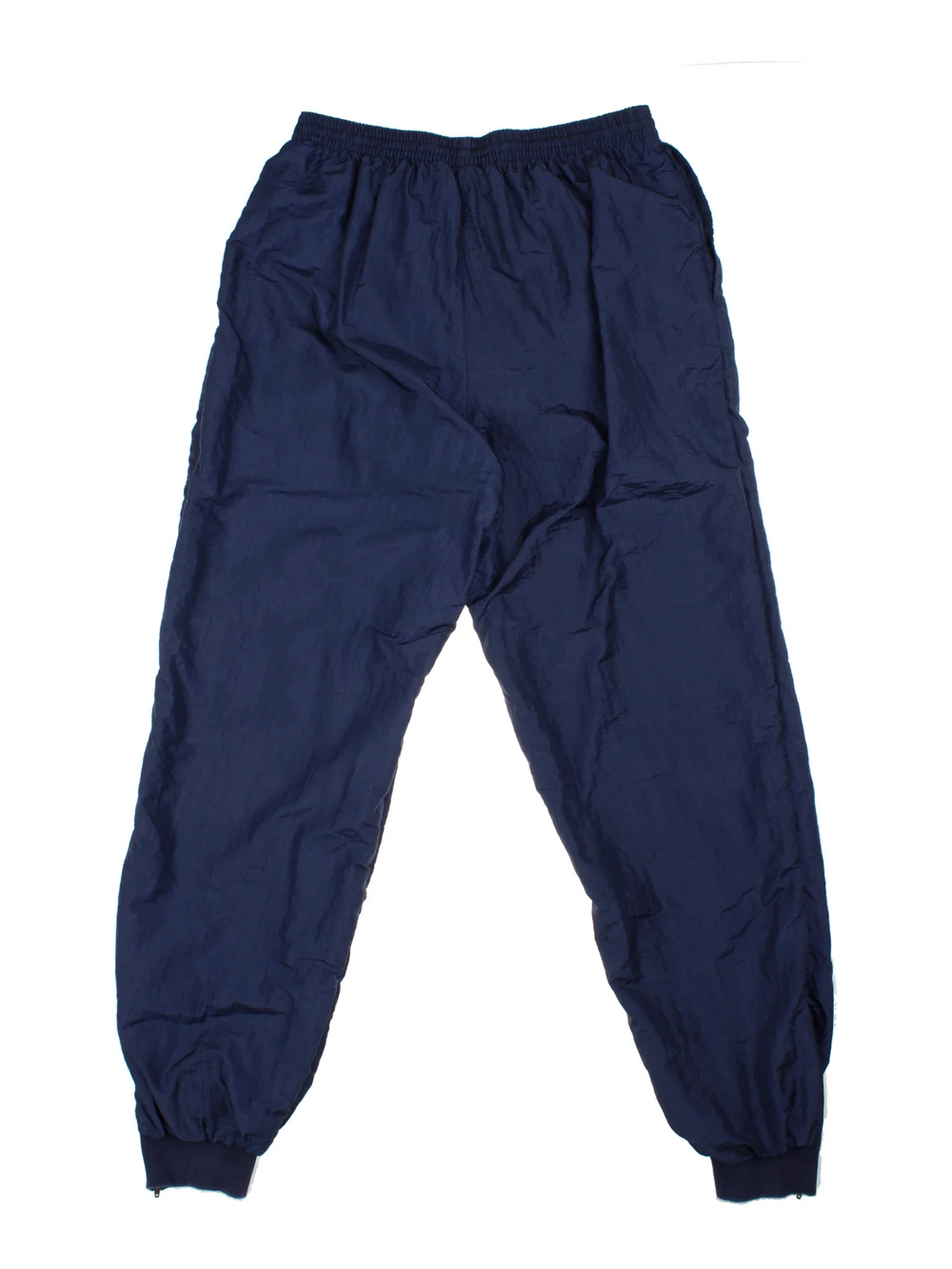 Vintage Lacoste Shell Pants in a blue colourway with pockets, elasticated waist with drawstring, cotton lining and the logo embroidered on the front.