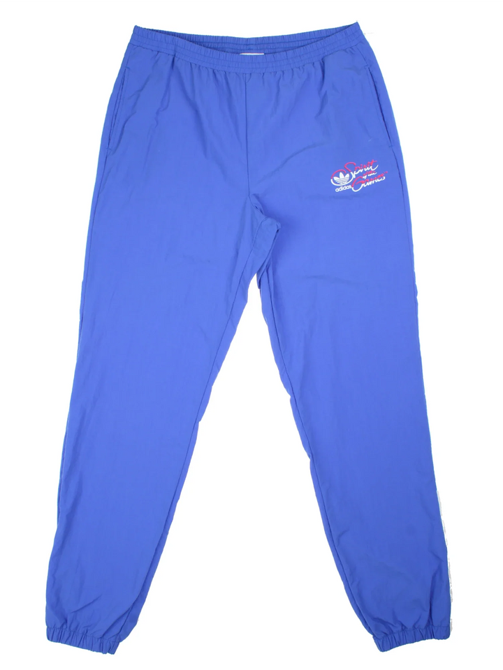 Vintage 80's Adidas Olympics Spirit Of The Games Tracksuit Bottoms in a blue colourway with pockets, elasticated waist, and the logo printed on the front.