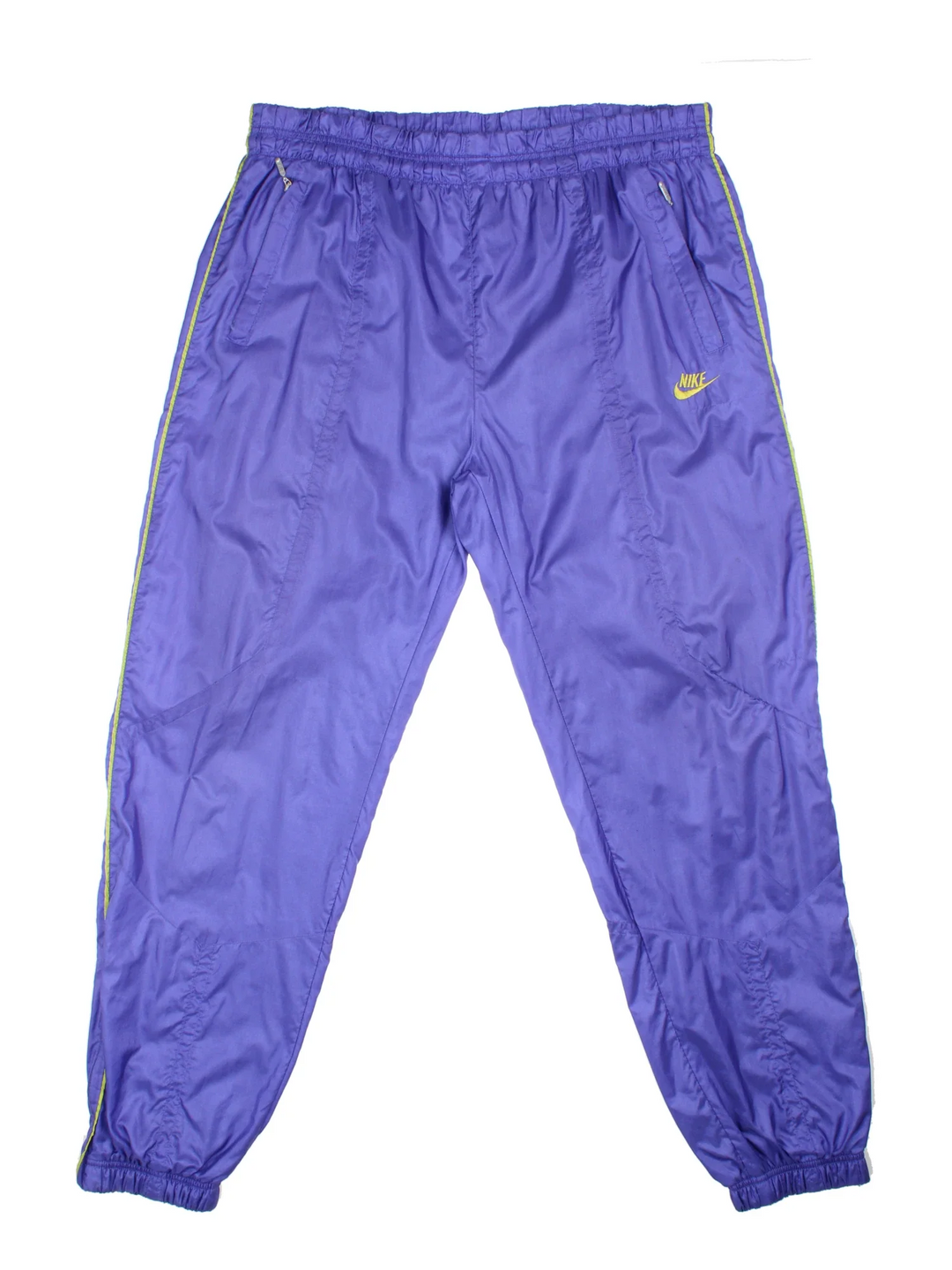 Vintage 80's Nike Shell Pants in a purple colourway with pockets, elasticated waist with drawstring, cotton blend lining, and the logo embroidered on the front.