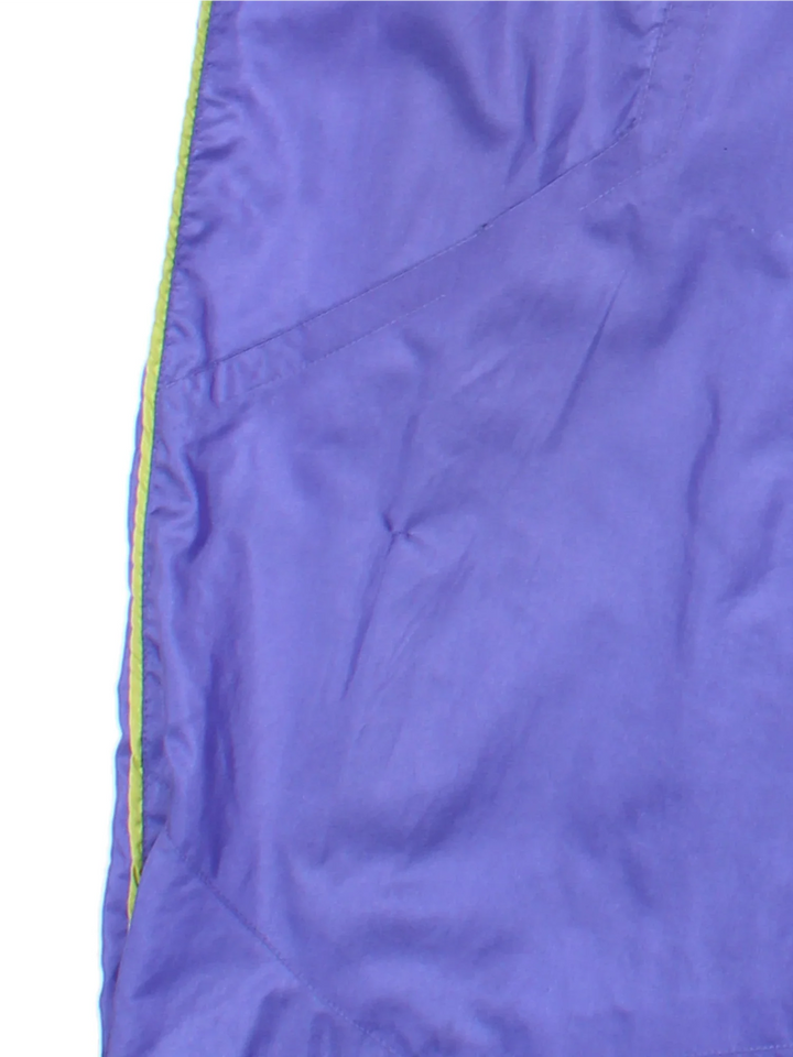 Vintage 80's Nike Shell Pants in a purple colourway with pockets, elasticated waist with drawstring, cotton blend lining, and the logo embroidered on the front.