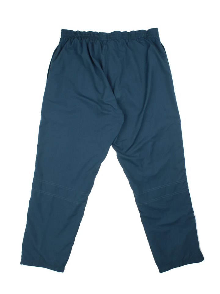 Reebok Tracksuit Bottoms in a blue colourway with pockets, elasticated waist, and the logo embroidered on the front.