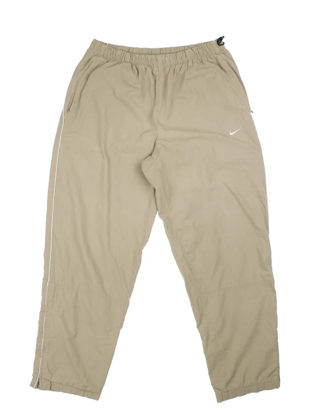 Nike Tracksuit Bottoms in a tan colourway with pockets, elasticated waist, cotton blend lining, and the swoosh logo embroidered on the front.