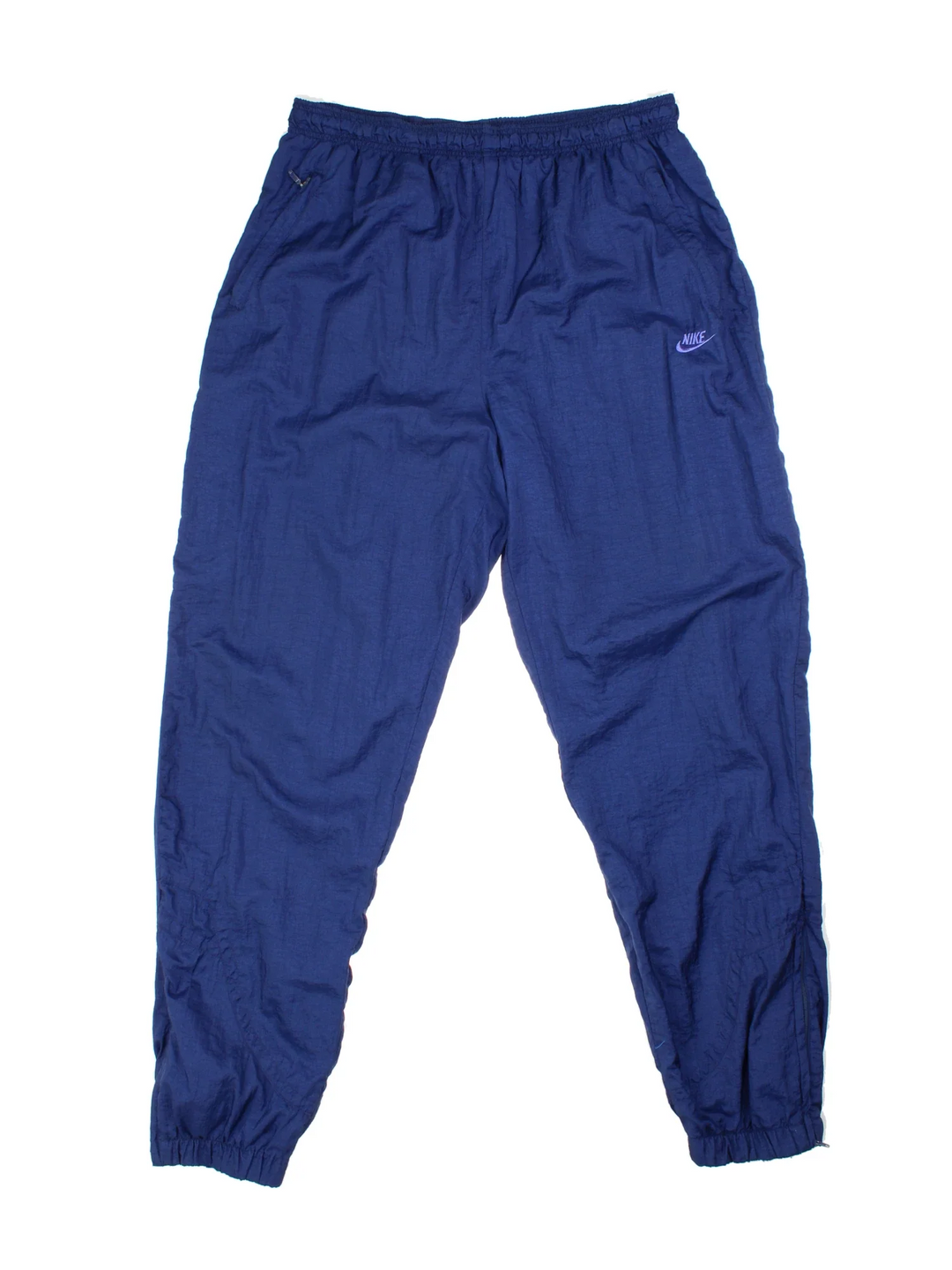 Vintage 90's Nike Shell Tracksuit Bottoms in blue colourway, has pockets, elasticated waist with drawstring, cotton blend lining, and the logo embroidered on the front.