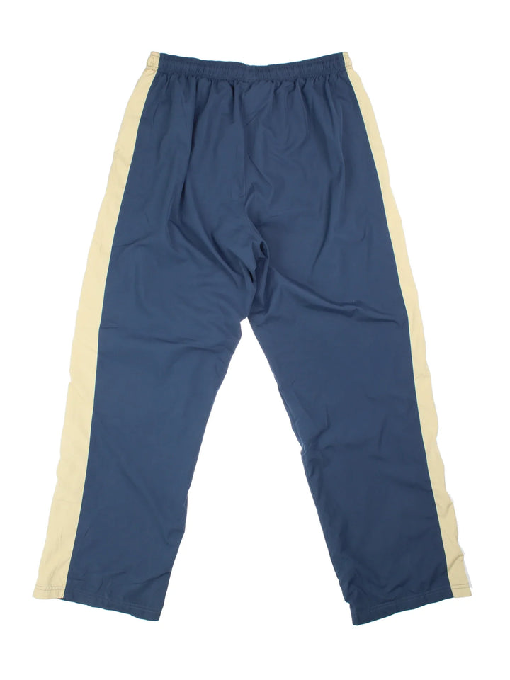 Reebok Tracksuit Bottoms in blue colourway, has pockets, elasticated waist with drawstring, cotton blend lining, and the logo embroidered on the front by the hem.
