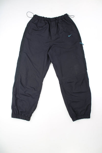 Nike The Athletic Dept black tracksuit bottoms with elasticated toggle pull waist. Features embroidered logo.